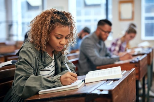 Student writing in a classroom